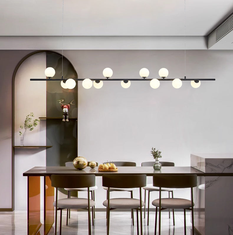 Lámpara colgante Ágata sobre una mesa de comedor frente a un arco