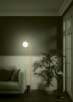 Cala lámpara de pie encendida junto a un sillón en sala