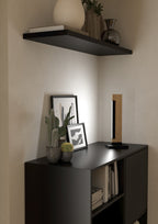 Lámpara de mesa Aldara sobre mueble negro en recibidor