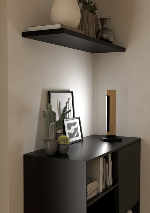 Lámpara de mesa Aldara sobre mueble negro en recibidor