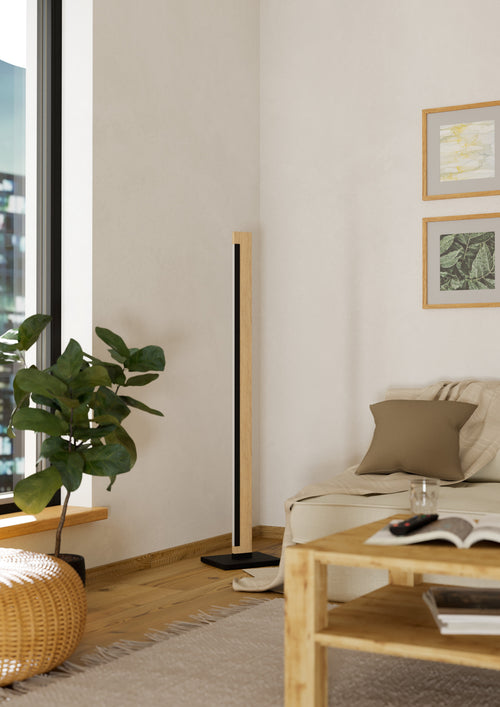Lámpara de piso Aldara junto a sofá en sala luminosa
