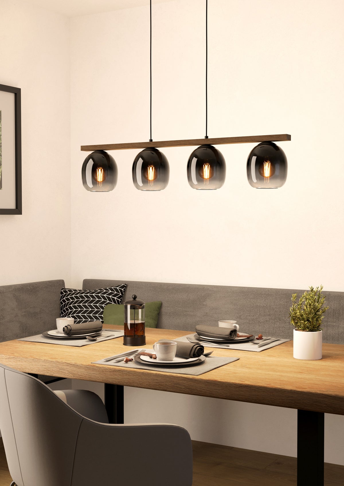 Ceniza lineal lámpara colgante encendida sobre una mesa de comedor de madera